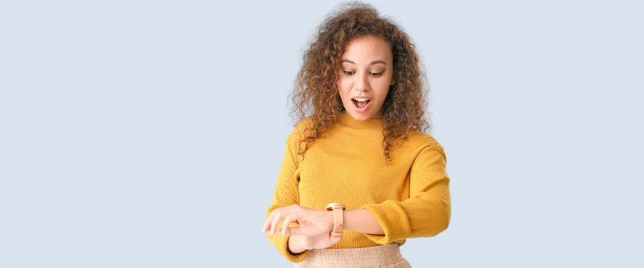 Women in a yellow shirt looking at a wrist watch looking surprised | Prolong Lash